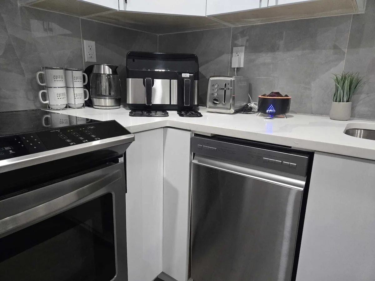 Kitchen with range, dishwasher, and coffee station